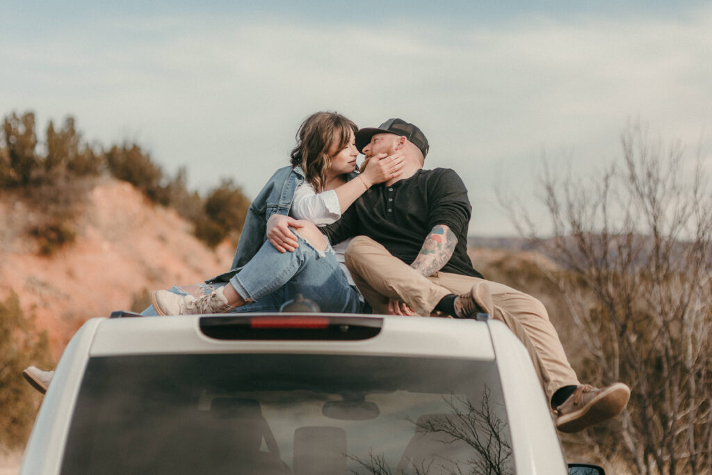 Couple sitting on top of land rover
